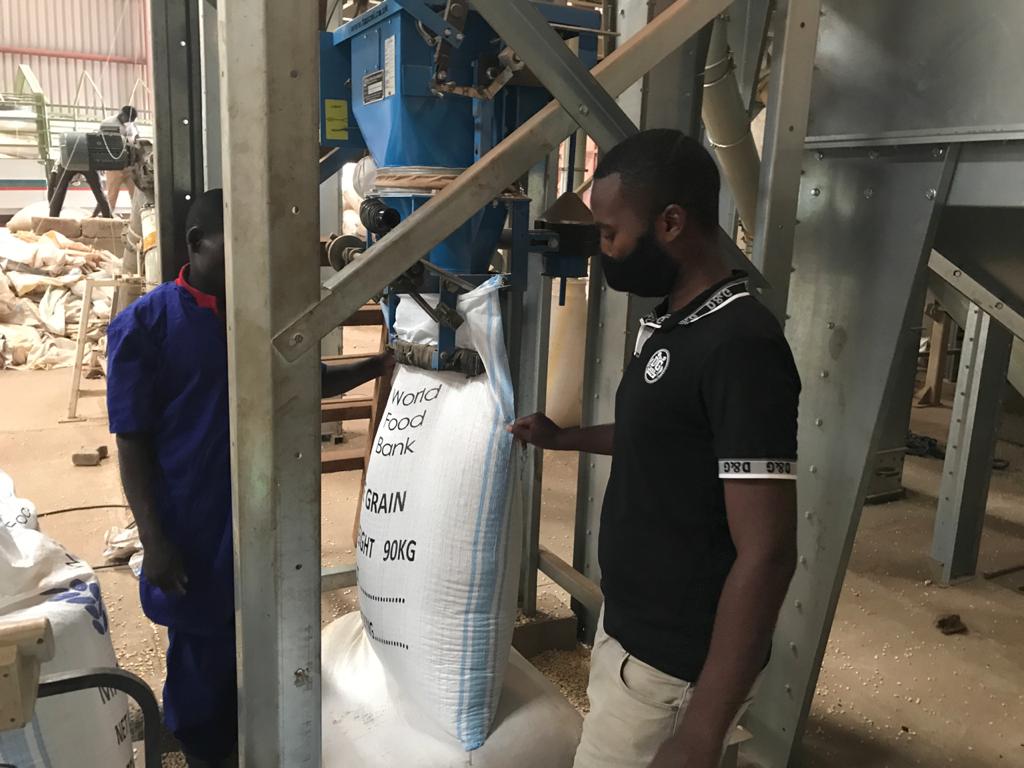 Bagging maize grain at 90kg per bag on the World Food Bank line.