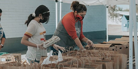 people filling bags of food